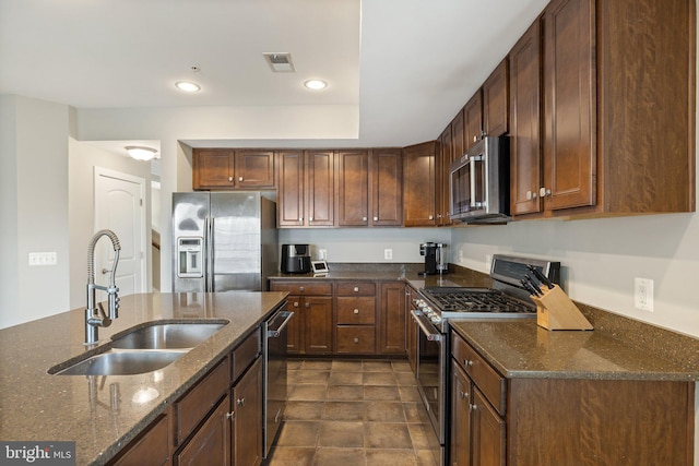 kitchen featuring visible vents, recessed lighting, dark stone counters, a sink, and stainless steel appliances