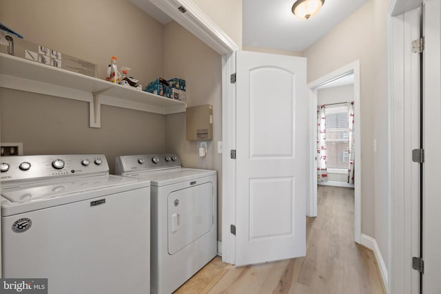 laundry area featuring laundry area, washer and clothes dryer, baseboards, and light wood-type flooring
