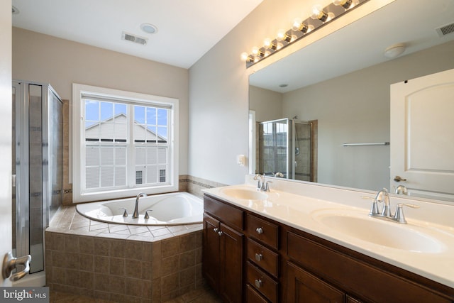 bathroom featuring a sink, a garden tub, a stall shower, and visible vents