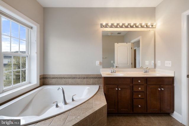 full bathroom featuring double vanity, tile patterned flooring, a sink, and a bath