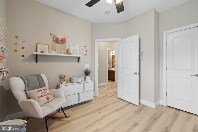 sitting room featuring ceiling fan, baseboards, and light wood-type flooring