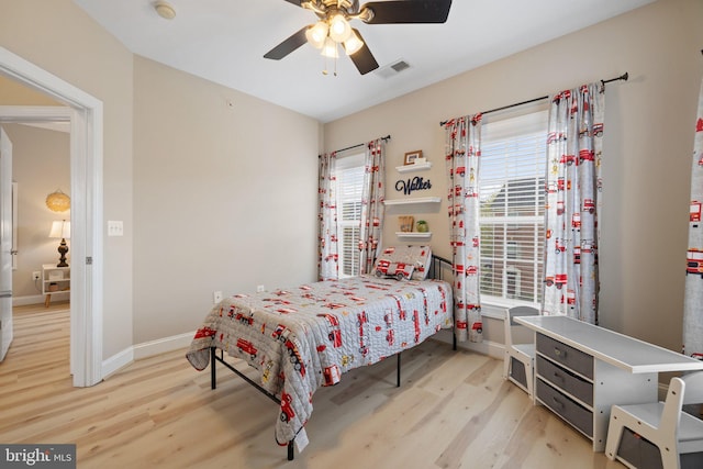 bedroom featuring visible vents, a ceiling fan, baseboards, and wood finished floors