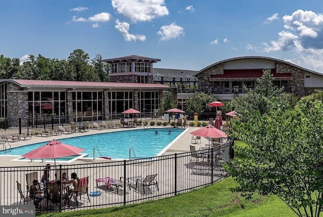 community pool with fence and a patio area