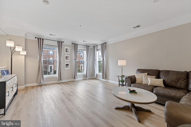 living room with light wood-type flooring, ornamental molding, baseboards, and visible vents