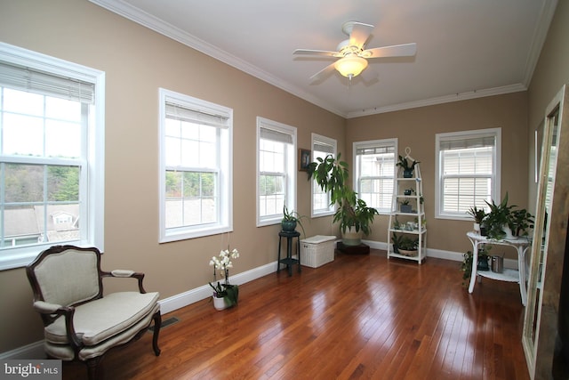 living area featuring baseboards, a ceiling fan, hardwood / wood-style flooring, and ornamental molding