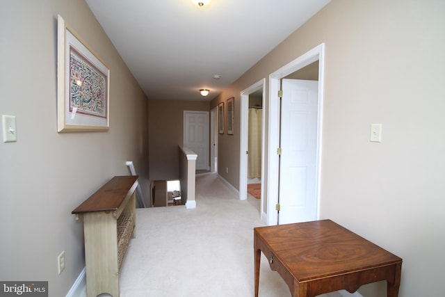 hallway with light carpet and baseboards