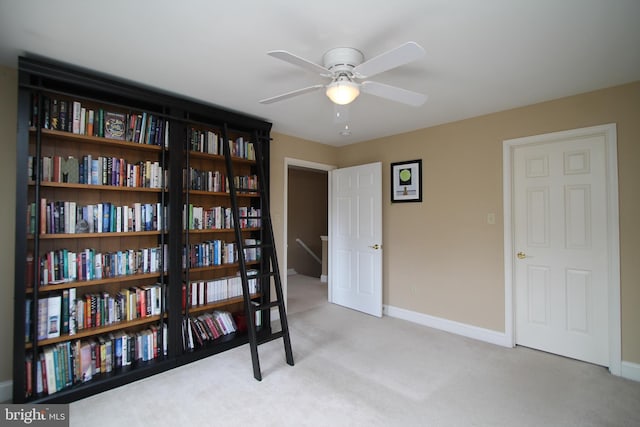 interior space with carpet floors, baseboards, and ceiling fan