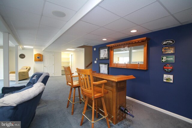bar with a paneled ceiling, baseboards, a dry bar, and carpet flooring