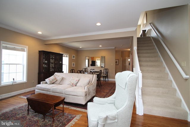 living area with stairway, baseboards, ornamental molding, and wood finished floors