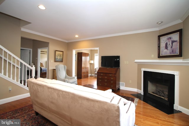 living room featuring baseboards, crown molding, wood finished floors, and visible vents