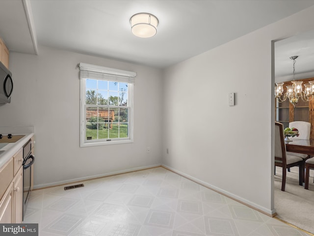 unfurnished dining area featuring an inviting chandelier and baseboards