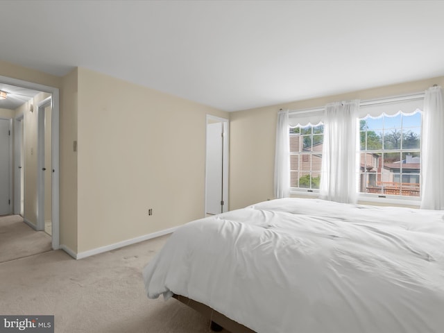 bedroom featuring baseboards and light carpet