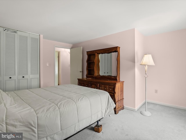 carpeted bedroom featuring baseboards and a closet