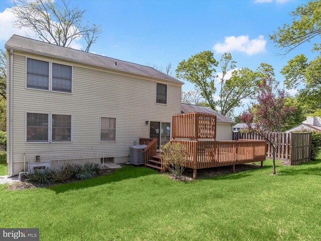 rear view of property with a yard, a deck, central AC, and fence