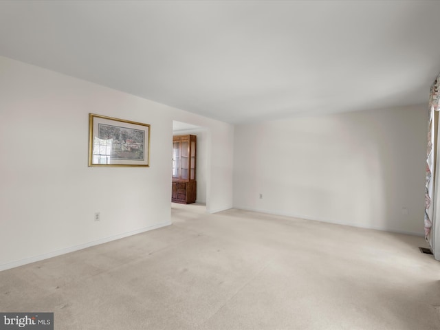 unfurnished room with visible vents and light colored carpet