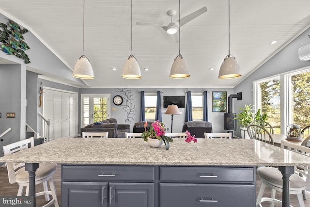 kitchen with open floor plan, vaulted ceiling, a kitchen island, and a kitchen breakfast bar