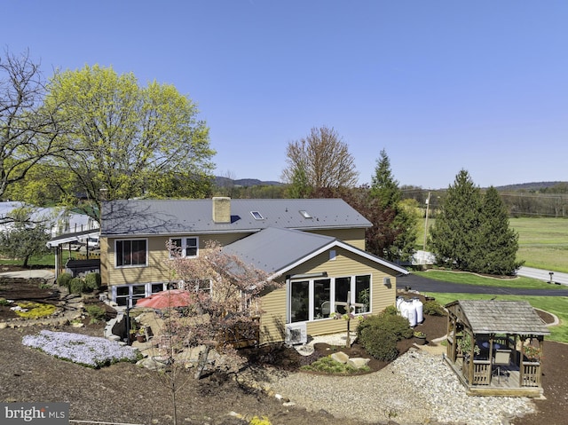 back of house featuring a chimney