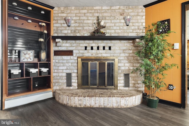 unfurnished living room featuring visible vents, wood finished floors, a brick fireplace, and a baseboard radiator