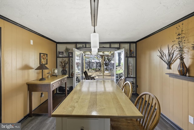 dining room with dark wood-style floors, a textured ceiling, and ornamental molding