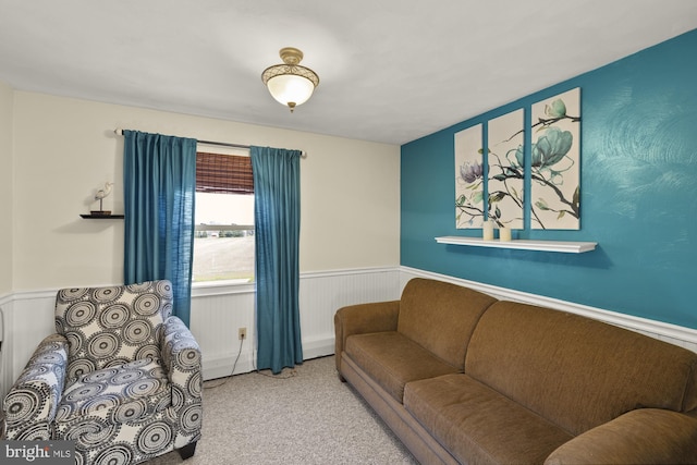 living area with carpet floors and a wainscoted wall