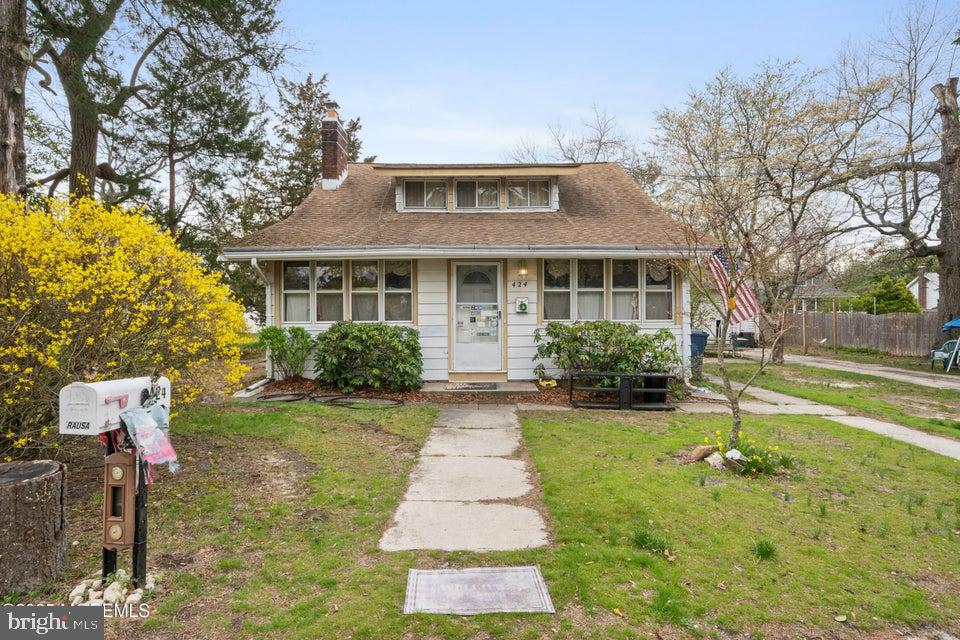 424 Beacon Ave, Beachwood, NJ 08722 - bungalow-style home with a chimney, fence, roof with shingles, and a front yard