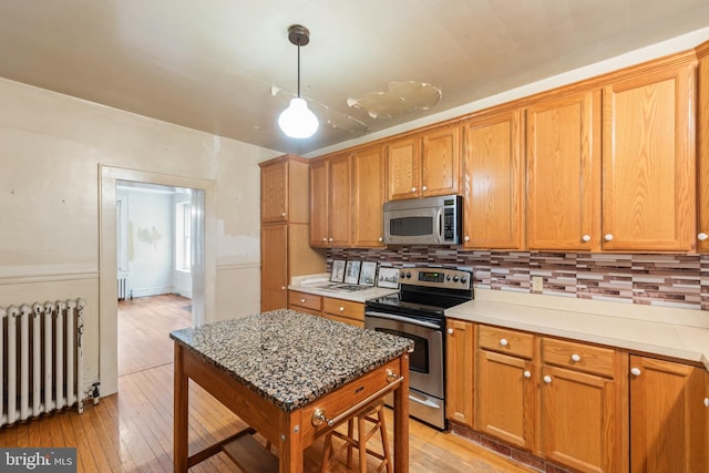 5342 Main St, Stephens City, VA 22655 - kitchen featuring stainless steel appliances, radiator, light wood-style flooring, and backsplash