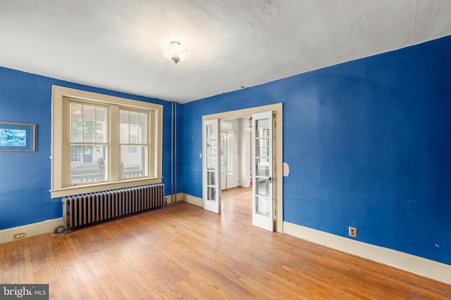 5342 Main St, Stephens City, VA 22655 - empty room featuring radiator, wood finished floors, french doors, and baseboards
