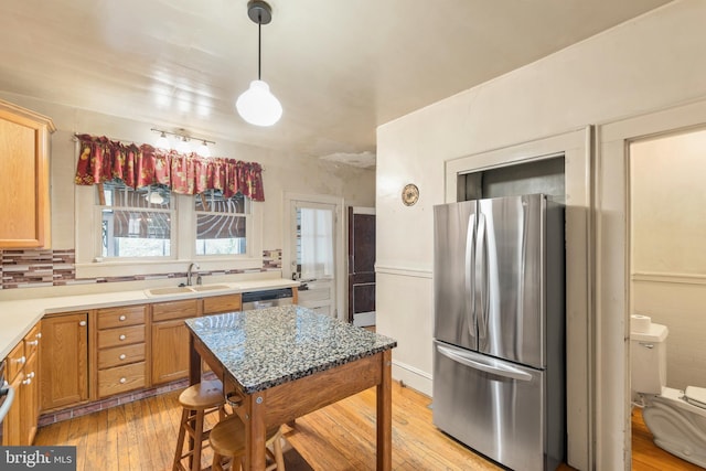 5342 Main St, Stephens City, VA 22655 - kitchen with appliances with stainless steel finishes, a sink, light wood finished floors, decorative light fixtures, and light countertops