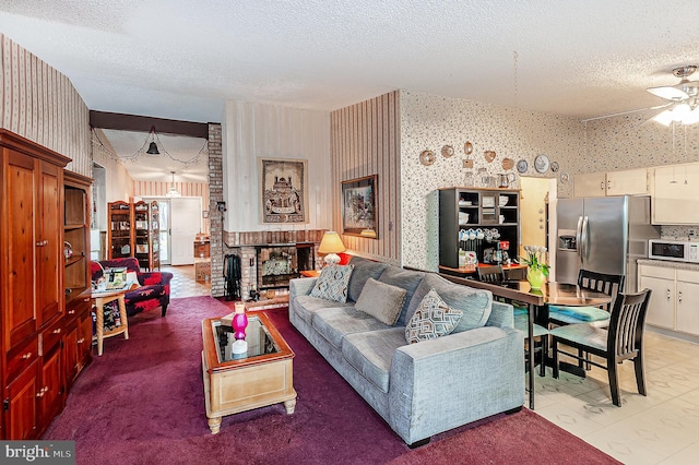 living area with wallpapered walls, a textured ceiling, and a ceiling fan