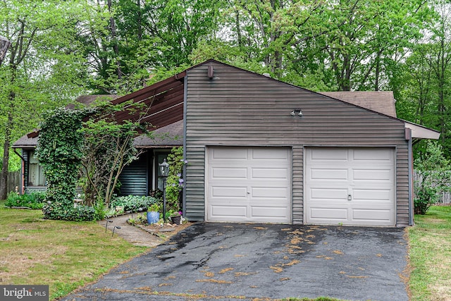 view of front facade with asphalt driveway and a shingled roof