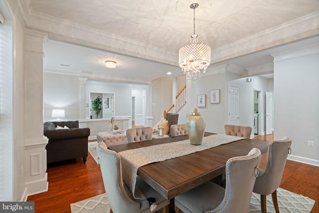 dining area with wood finished floors, a chandelier, stairs, and crown molding