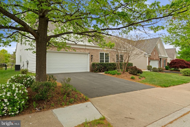 view of front of house featuring central AC, driveway, brick siding, a front yard, and a garage