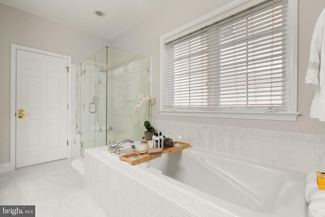 bathroom featuring a garden tub and a shower stall