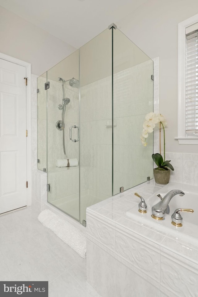 bathroom with a bath, tile patterned flooring, and a shower stall