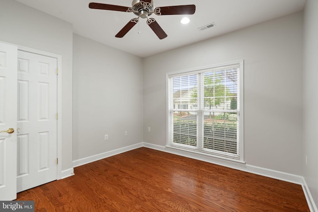 interior space with wood finished floors, visible vents, a ceiling fan, and baseboards