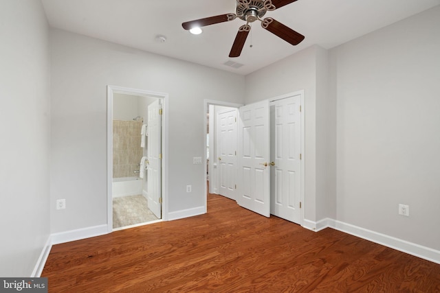 unfurnished bedroom with baseboards, visible vents, a ceiling fan, wood finished floors, and connected bathroom
