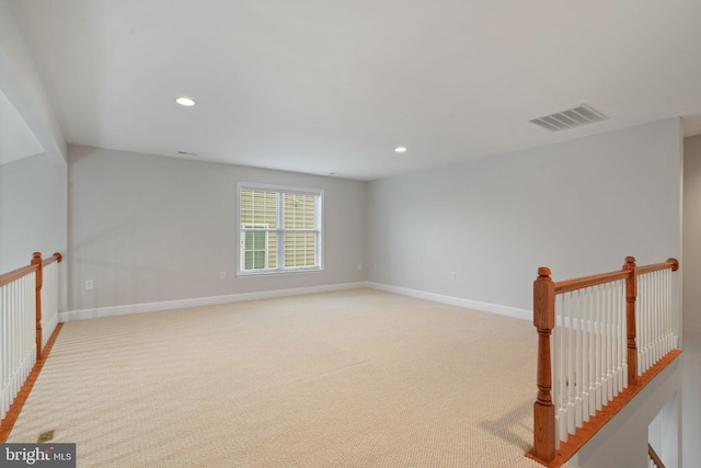 spare room with recessed lighting, visible vents, baseboards, and light carpet
