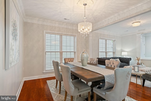 dining space featuring a chandelier, wood finished floors, visible vents, and baseboards