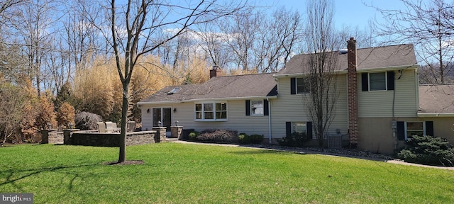 rear view of property with a chimney and a yard