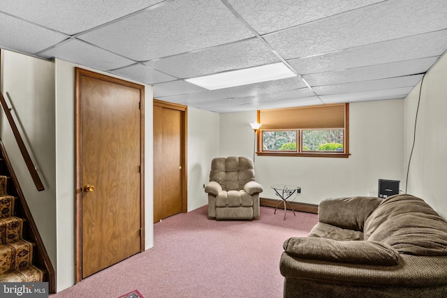 carpeted living area with a paneled ceiling and a baseboard radiator