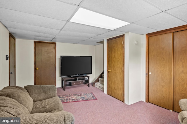 carpeted living area featuring stairway and a drop ceiling