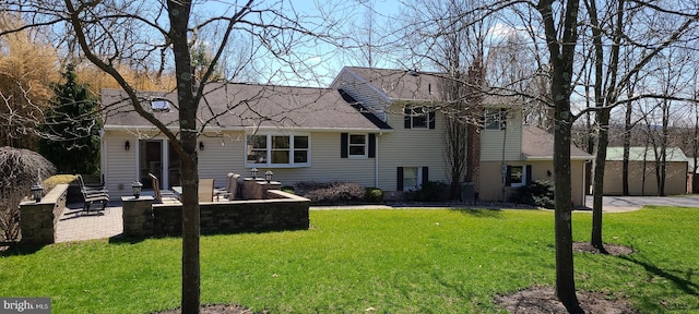 back of property with a lawn and roof with shingles