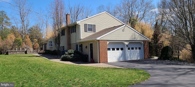 view of property exterior with a chimney, driveway, an attached garage, and a lawn