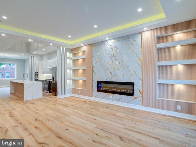 1021 E Palmer St, Philadelphia, PA 19125 - unfurnished living room featuring light wood-type flooring, a high end fireplace, baseboards, built in shelves, and recessed lighting
