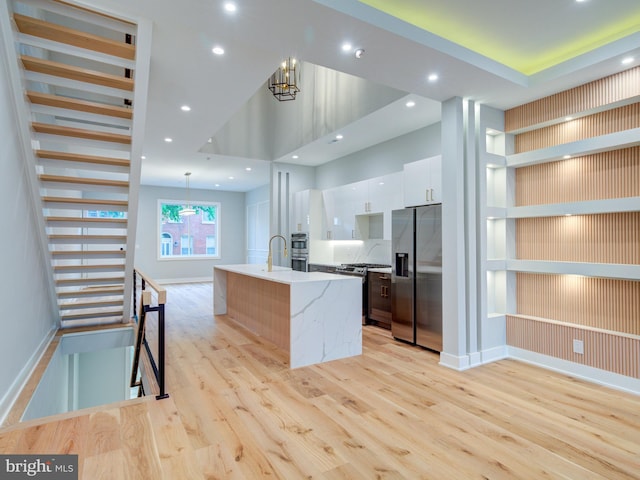 1021 E Palmer St, Philadelphia, PA 19125 - kitchen featuring stainless steel appliances, a chandelier, light wood-style floors, modern cabinets, and white cabinets