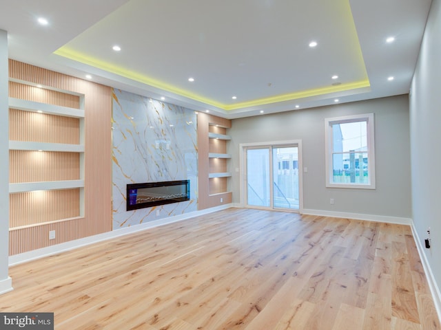 1021 E Palmer St, Philadelphia, PA 19125 - unfurnished living room with a raised ceiling, built in shelves, wood finished floors, a premium fireplace, and baseboards