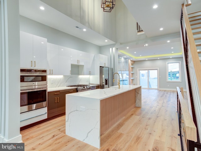 1021 E Palmer St, Philadelphia, PA 19125 - kitchen with appliances with stainless steel finishes, modern cabinets, light wood finished floors, white cabinets, and a high ceiling