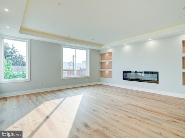 1021 E Palmer St, Philadelphia, PA 19125 - unfurnished living room with a raised ceiling, a glass covered fireplace, wood finished floors, built in shelves, and baseboards