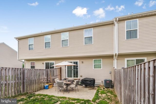 rear view of house featuring a fenced backyard, cooling unit, and a patio area