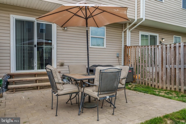 view of patio / terrace with fence, outdoor dining space, and entry steps